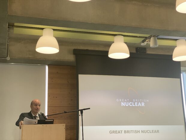 Brian Robinson from Great British Nuclear is standing at a podium, addressing a room of people at the Foresight Nuclear Live conference. His presentation is being projected onto a screen behind him.